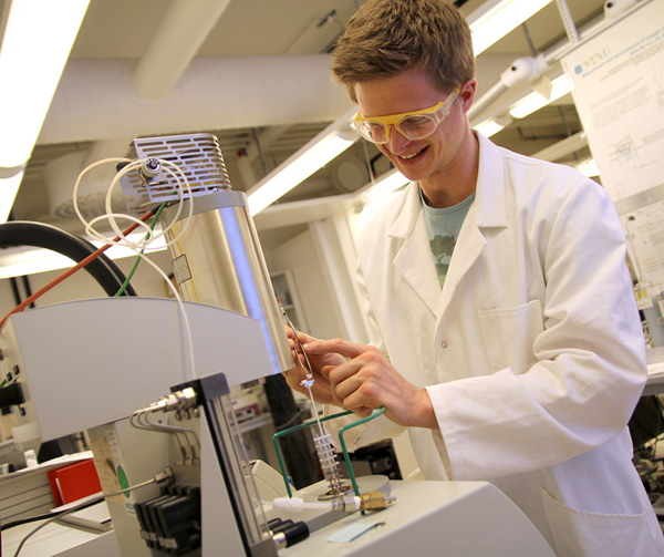 Picture of person in lab coat with experimental equipment.
